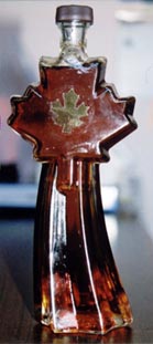 Buteleczka syropu klonowego , w kształcie drzewa klonu i jego liścia.
